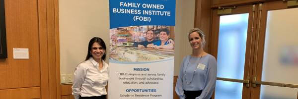 Two people standing in front of a FOBI banner